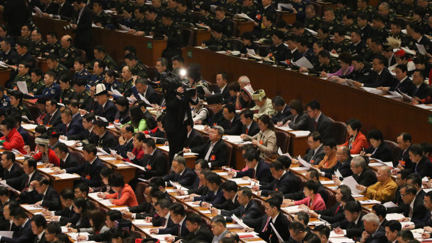 Delegates from all walks of life listen to the Government Work Report delivered by Li at the People’s Congress in Beijing.