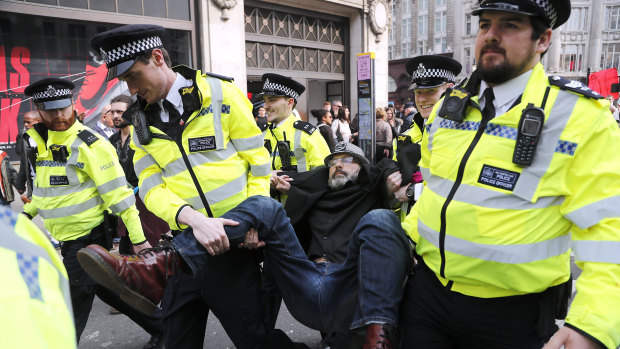 Police officers carry a protester away at Oxford Circus in London on Wednesday.