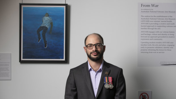 Artist Saif Shamkhi beside his painting <i>Pusser Post Resolute</i> hanging at Parliament House.