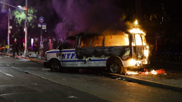 A Police vehicle burns after protesters rallied in New York on Friday over the death of George Floyd, a black man who died in Minneapolis police custody