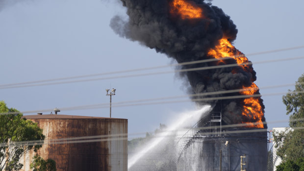 Firefighters work to extinguish a fire in an oil facility in the southern Lebanese town of Zahrani.