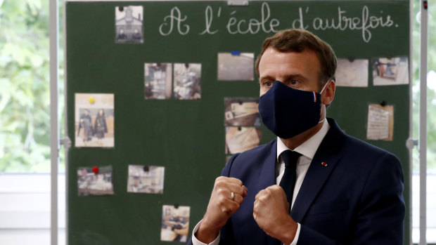 Fighting spirit: President Emmanuel Macron, wearing the new 100 per cent French face mask, speaks with children during class at the Pierre Ronsard elementary school on Tuesday.