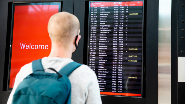 A traveller in Sydney looks at cancellations from Melbourne at Sydney airport.