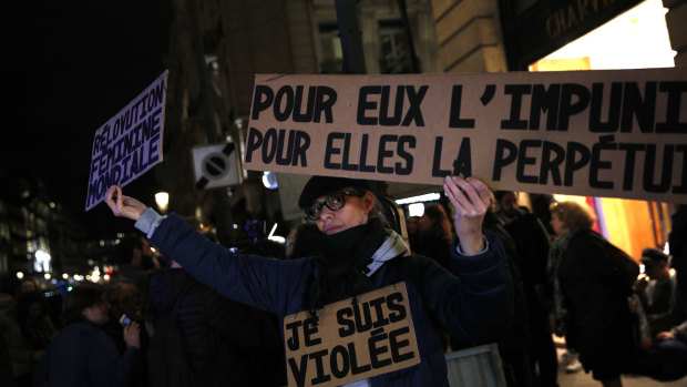An activist holding a banner reading: “For him impunity, for her a life sentence” during a protest in Paris after a 2017 sexual assault case the court refused to upgrade to rape. 