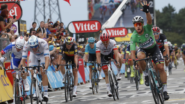 Peter Sagan, right, wearing the best sprinter's green jersey, crosses the finish line in stage 13.
