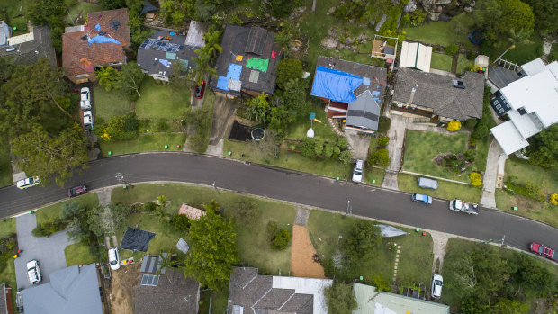 Many homes in Berowra Heights had their roofs covered in tarpaulins on Friday. 