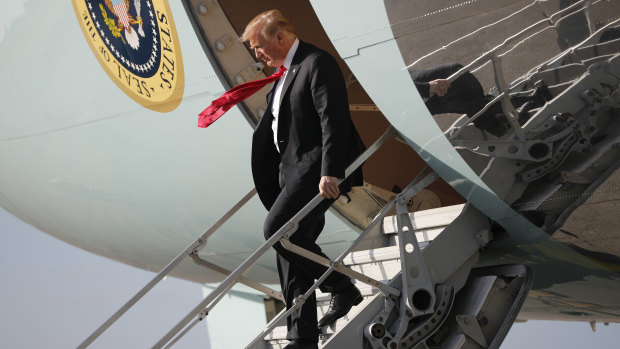 Donald Trump walks down the stairs of Air Force One during his arrival at Palm Beach International Airport.