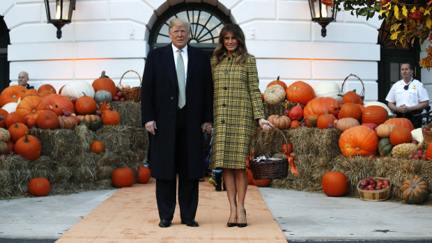 US President Donald Trump and first lady Melania Trump hold hands after arriving for a Halloween trick-or-treat event at the White House.