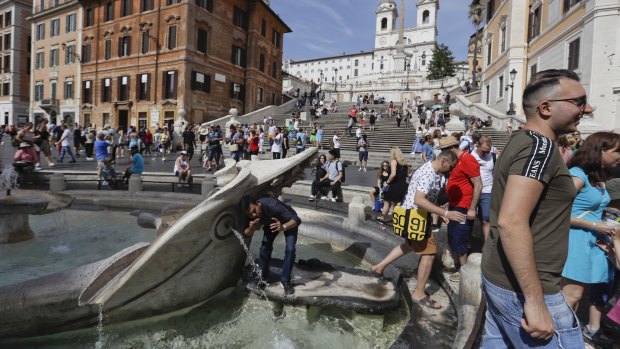 A man takes a selfie while drinking from the Bernini's 17th-century Barcaccia fountain, at the foot of the Spanish Steps in Rome.