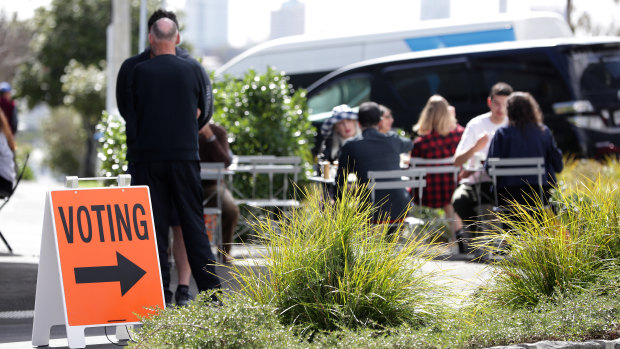 People sit outside at an Auckland cafe near an early voting polling booth on Thursday.