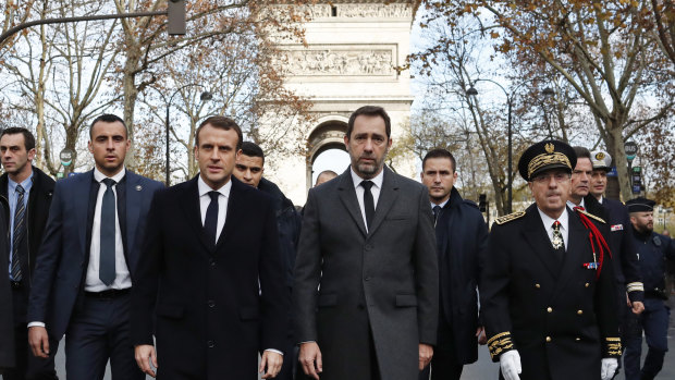 France's President Emmanuel Macron, Interior Minister Christophe Castaner, centre right, and Paris police Prefect Michel Delpuech, right, arrive to visit firefighters and riot police officers the day after a demonstration, in Paris.