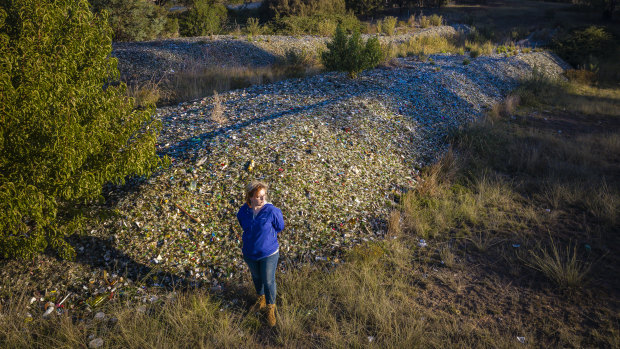 Caitlin Miller with about 900 tonnes of glass she says was dumped on her Bywong property by her father, Garry Miller, without permission. 