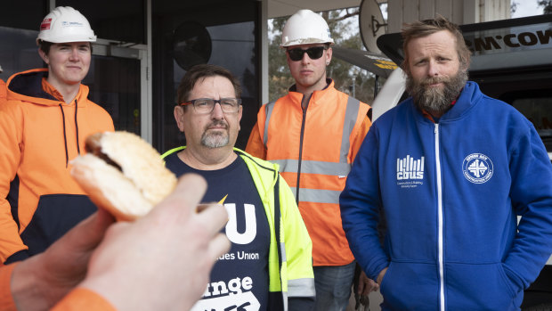 Electrical Trades Union officer Matt McCann and Construction, Forestry, Maritime, Mining and Energy Union site delegate Leon Arnold with light rail electricians at a barbecue outside the light rail depot in Mitchell on Friday.