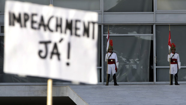 A sign written in Portuguese that reads “Impeachment Now!” is held during a protest against the Brazilian President’s response to the pandemic, in front of the presidential palace in Brasilia on Sunday.