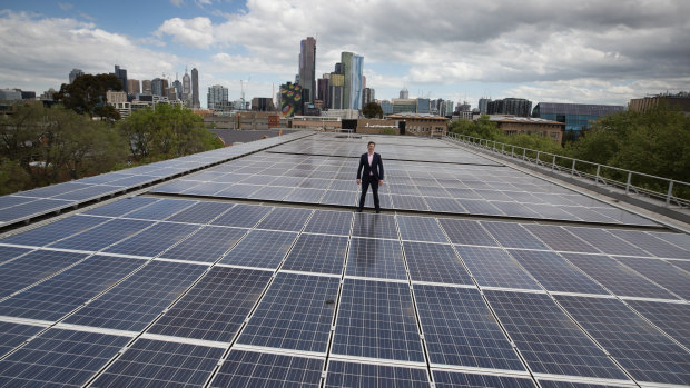 Cr Nick Reece on a roof with solar powered panels.