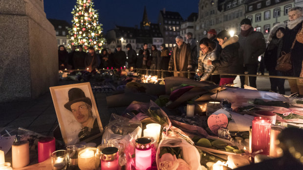 People place candles near the scene of the attack in Strasbourg, France.