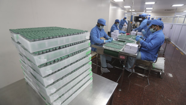 Employees pack boxes containing vials of AstraZeneca’s COVID vaccine at the Serum Institute of India, in Pune.