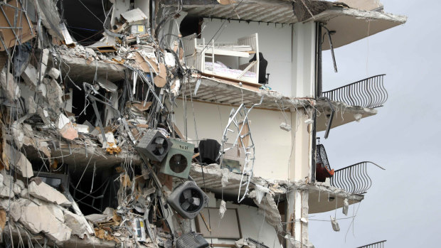 Debris dangles from a section of the collapsed apartment building.