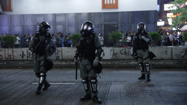 Hong Kong police in anti-riot gear patrol the streets.
