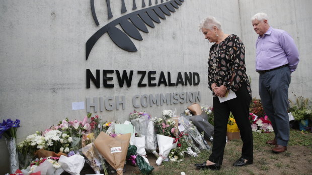 New Zealand High Commissioner Dame Annette King and husband Ray Lind view flowers left at the front gate of the high commission in Canberra on Sunday, following the mass shooting in Christchurch