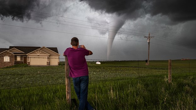 A Wyoming local watches a tornado meander through an estate west of the state capital Cheyenne.