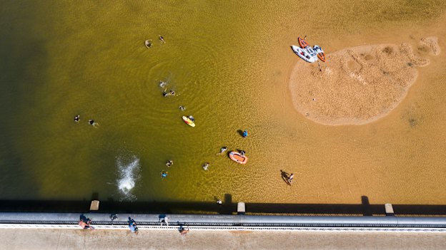 Kids jump from the Narabeen Bridge in Sydney during a heatwave in January 2021.