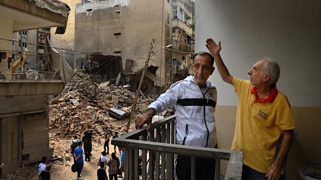  Twins Jamal and Mohammed al-Sheikh on the balcony of their damaged apartment.