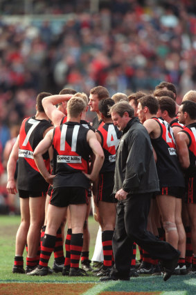 Kevin Sheedy walks past the Essendon huddle at three-quarter time.