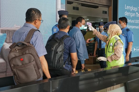 Local travellers checked for temperature at an airport in Jakarta on Monday. 