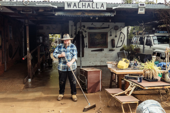 Les Davidson sweeps water in the front yard of his Traralgon home after the recent flooding in the Latrobe Valley.