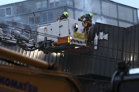 Firefighters clean up after a suspicious fire at Love Machine nightclub.