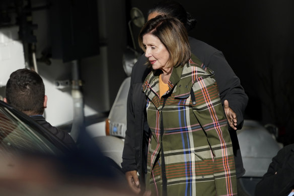 House Speaker Nancy Pelosi is escorted to a vehicle outside of her and husband Paul Pelosi’s home in San Francisco.