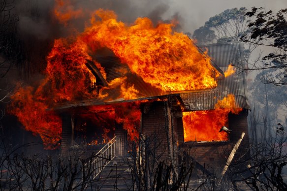 A home in flames in Dargan, on the Bells Line of Road, where one man is missing.