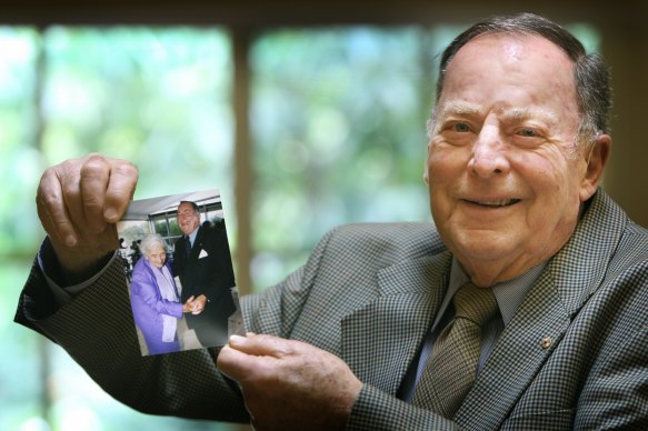 Geoff Handbury, pictured in 2014, holding a photo of himself with his late mother-in-law, Elisabeth Murdoch.