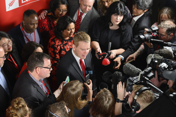 New Zealand Prime Minister Chris Hipkins, centre, speaks to media after conceding defeat at a party event in Wellington, on Saturday night.