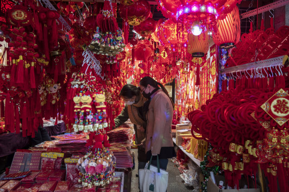 Customers look at red lanterns and decorations at a store at the Yuyuan Bazaar in Shanghai on Wednesday ahead of the Lunar New Year.