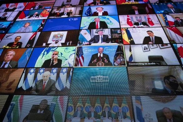 A video monitor shows President Joe Biden, centre, speaking during a virtual Leaders Summit on Climate.