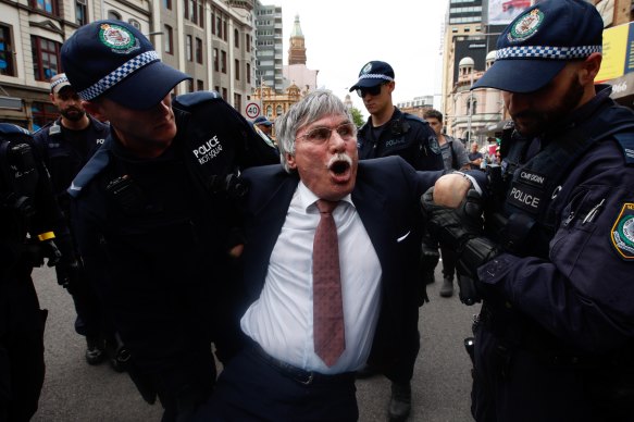 A man has his wrist bent as he is detained by police during the "Spring Rebellion" on October 7 in Sydney.