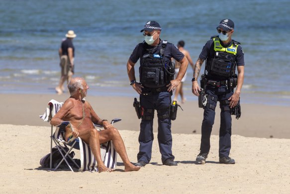 Police ask people to leave St Kilda beach during one of Melbourne’s lockdowns. 