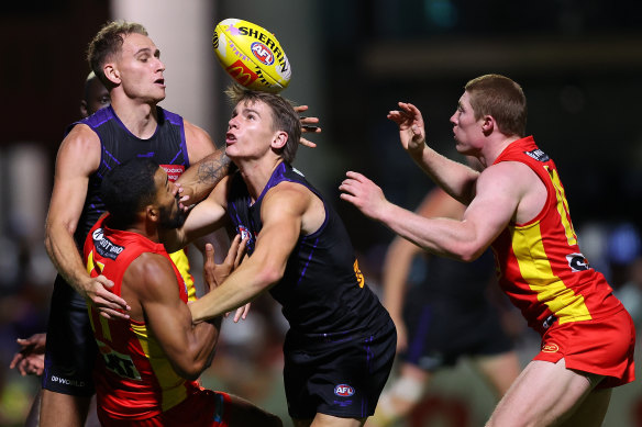 Touk Miller of the Suns and Caleb Serong of the Dockers contest for the ball during  round five.