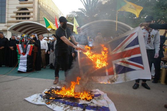 Supporters of the Iran-backed Kataeb Hezbollah militia burn representations of Israeli, US and British flags during a protest in Najaf, Iraq, on September 18, 2020. 