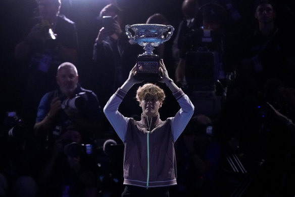 Jannik Sinner hoists the Australian Open trophy aloft.