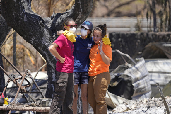 Women hug after digging through rubble of a home destroyed by this week’s fires in ahaina, Hawaii.