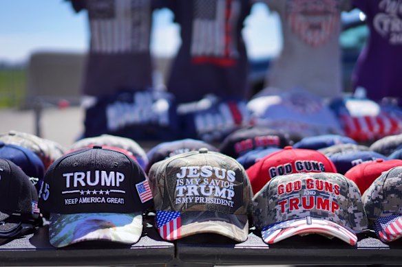 Hats reading, “God, Guns and Trump” and “Jesus is my saviour, Trump is my president” are sold at a campaign rally.