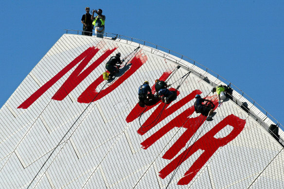 Workmen remove anti-Iraq War graffiti painted on the Opera House sails, 2003.