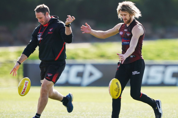 Ben Rutten, left, works with Bombers captain Dyson Heppell at training.