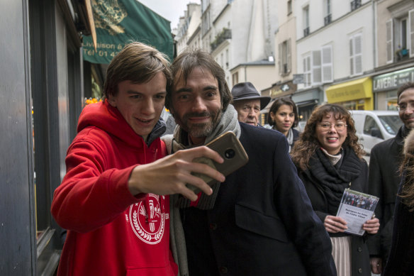 Cedric Villani (right) poses for a selfie while campaigning for mayor in Paris on January 25.