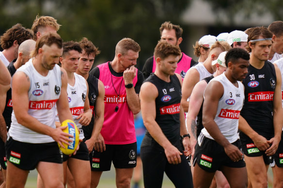 Collingwood coach Nathan Buckley (centre) with his players at training last month. 