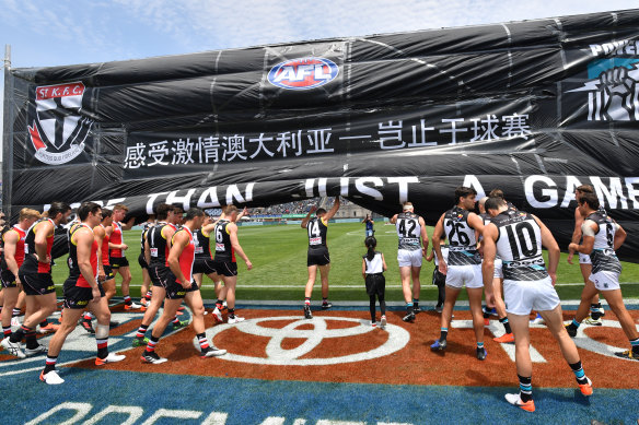 St Kilda and Port Adelaide players run through the banner before last year's match in Shanghai.