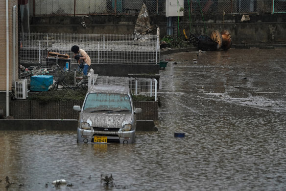 A woman cleans out her home in a still-flooded area in Koriyama, Japan.
